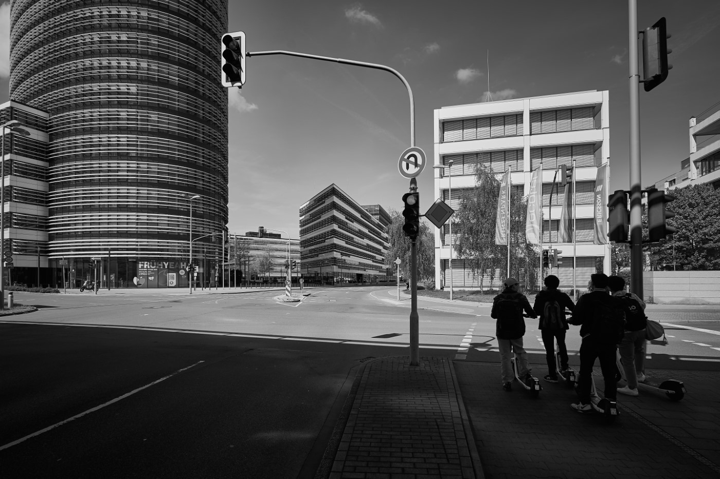 Eine Gruppe von E-Roller Fahrern blickt auf den Vodafone-Campus in Düsseldorf.